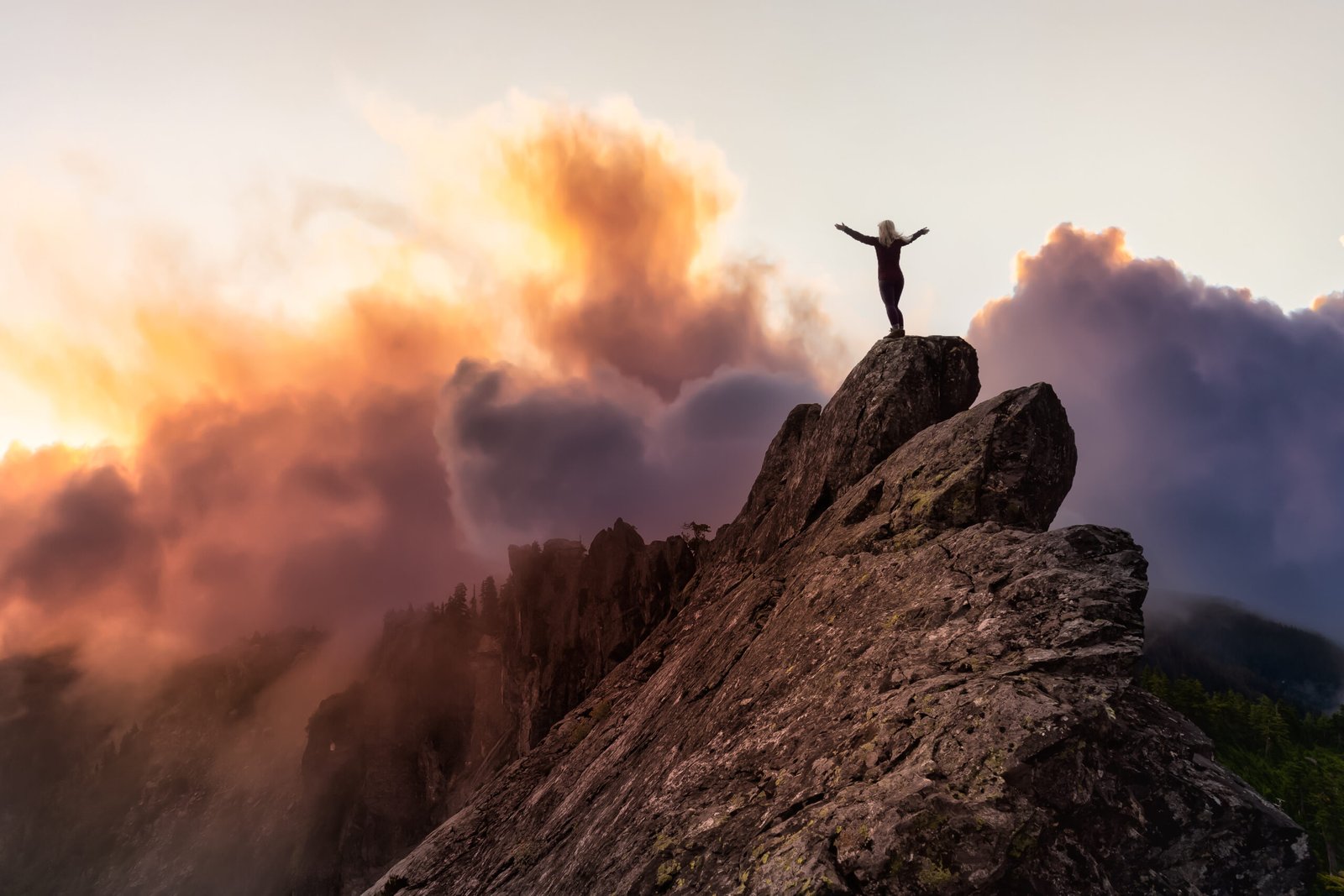 Adventurous Girl on top of a rugged rocky mountain. Dramatic Colorful Sunrise Sky Art Render. Taken on Crown Mountain, North Vancouver, BC, Canada.