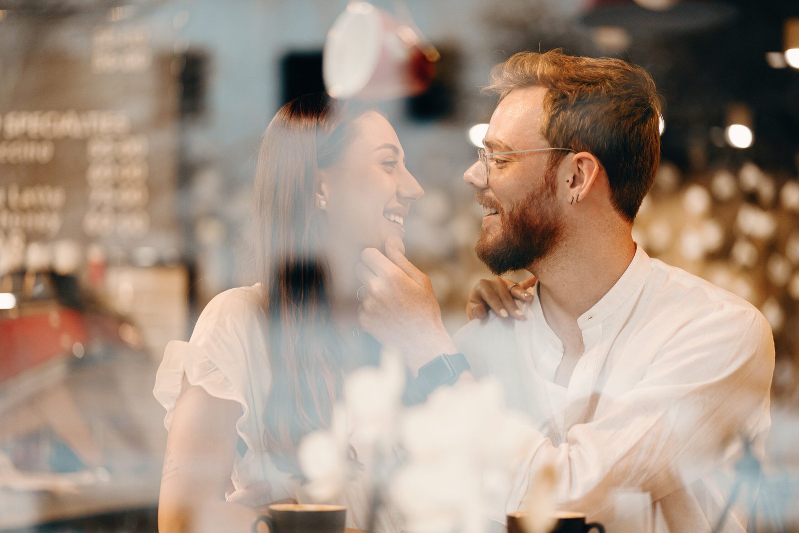 Loving couple in a coffee shop. Happy young couple is drinking coffee and smiling while sitting in a coffee shop