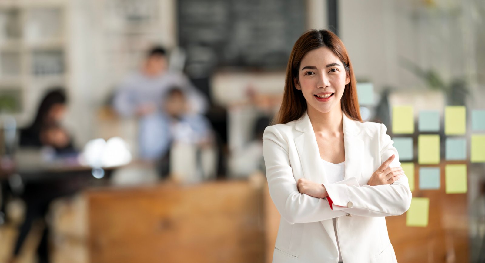 Successful businesswoman standing in creative office and looking at camera.