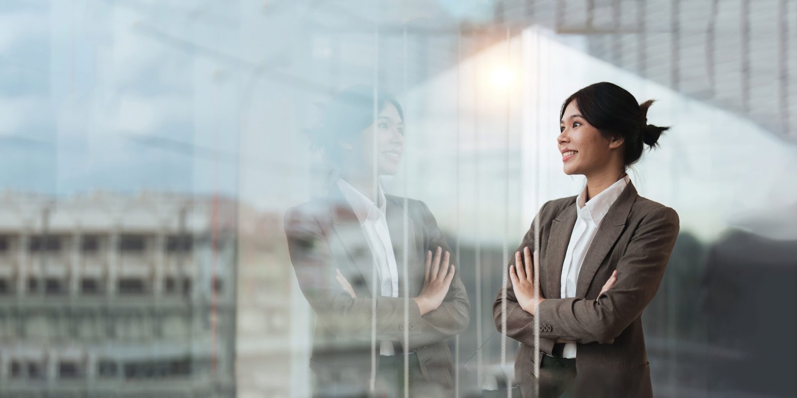 Young asian businesswoman looking out window in meeting room with confidence.