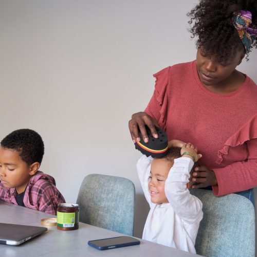 African mother styling her son hair using an afro curl wave or twists sponge.