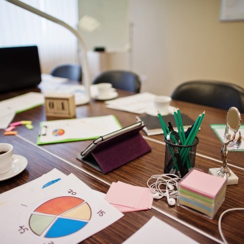 Modern creative workplace with laptop, tablet, equipment and table led lamp. Office design concept with graphics.