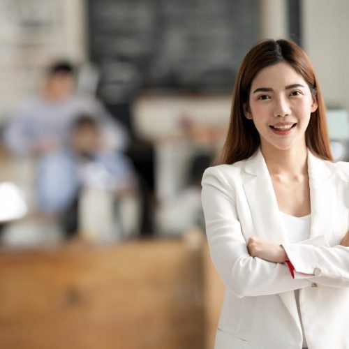 Successful businesswoman standing in creative office and looking at camera.